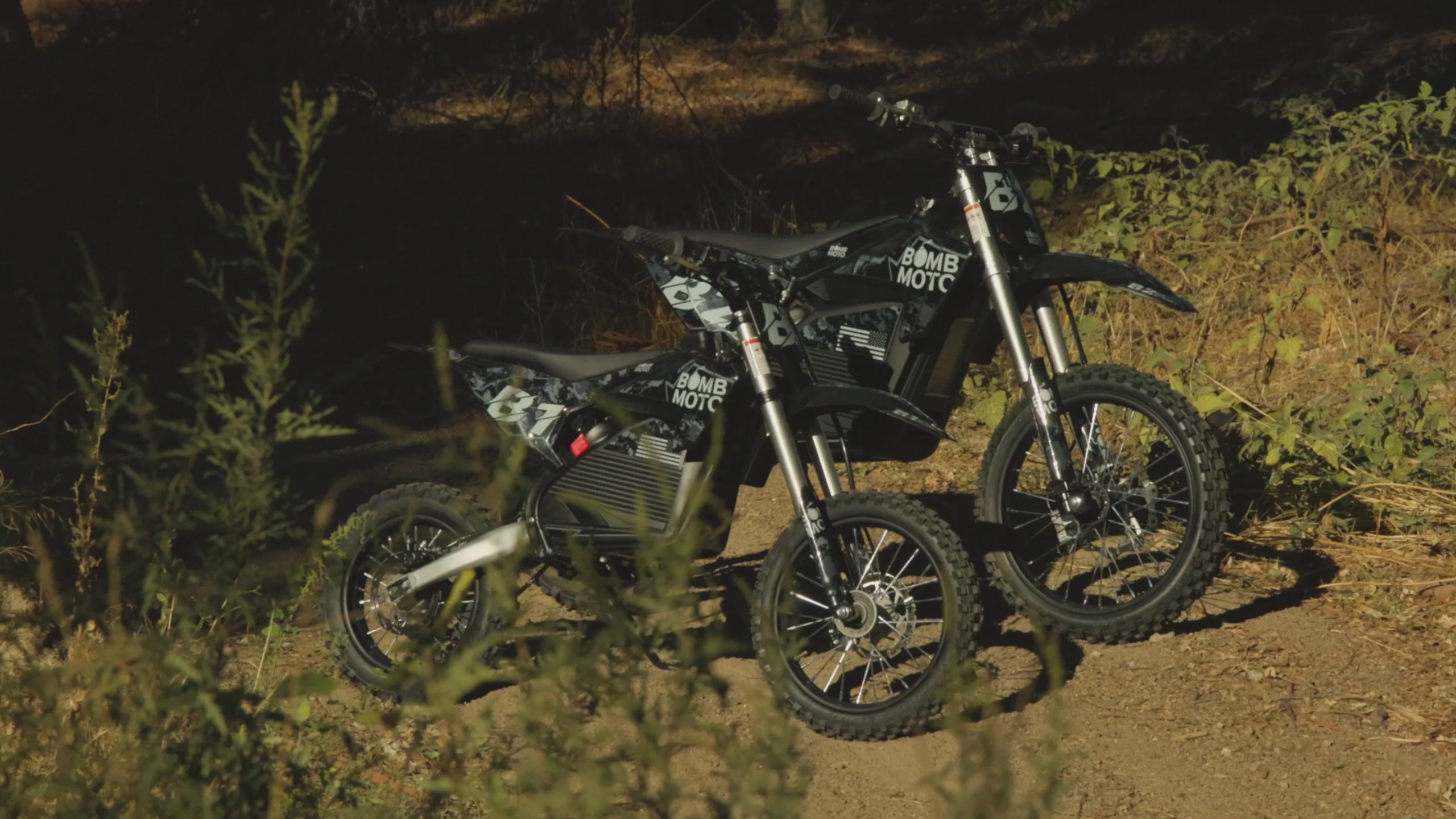 Load video: A looping video of a young man riding a Bomb Moto B1 electric dirt bike. He is seen jumping on a MX track and riding fast on a trail.